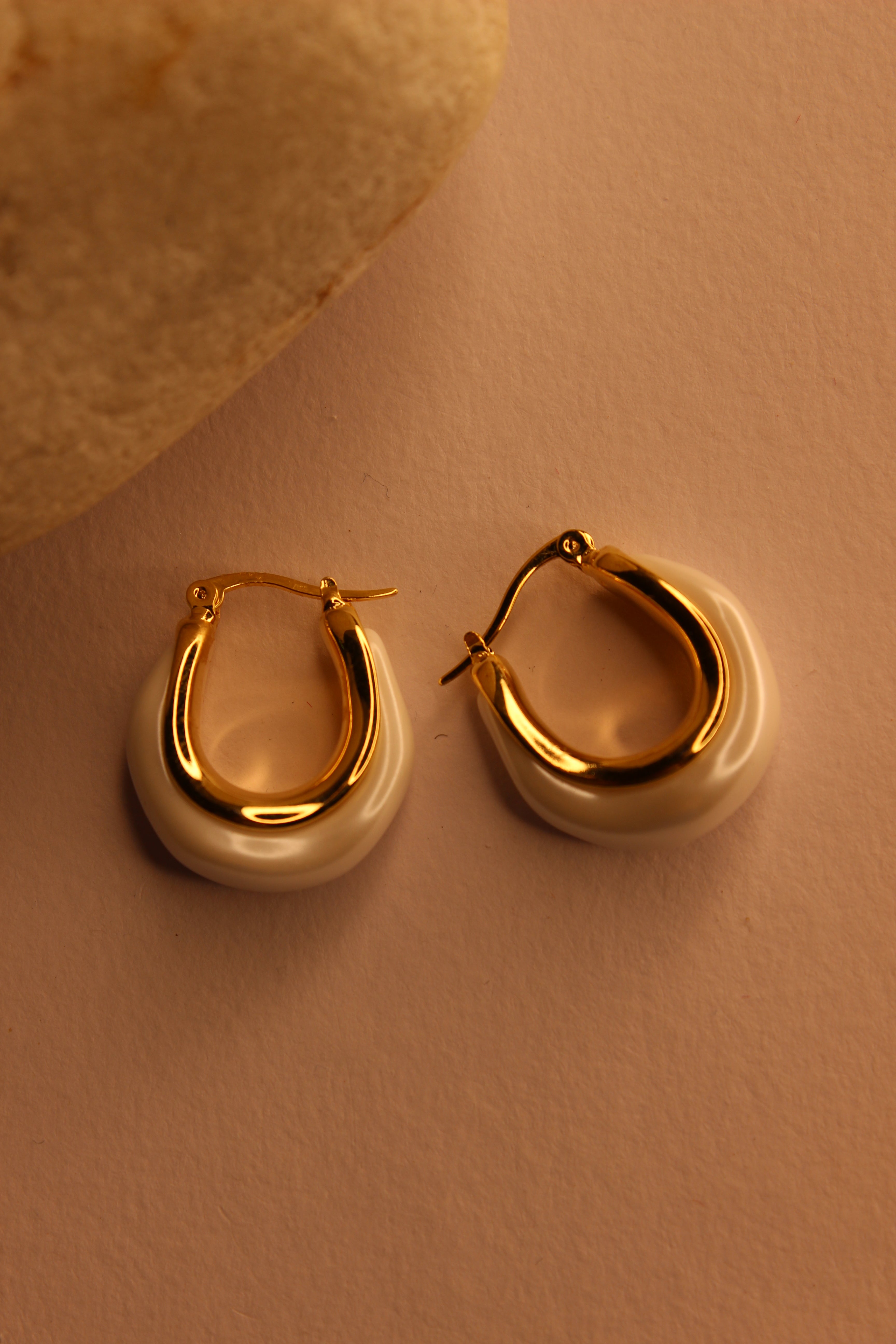 Mira Pearl Hoop Earrings on a light brown background