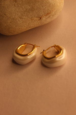 Mira Pearl Hoop Earrings on a beige background