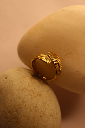 Adara Ring with leaf design on a beige stone surface