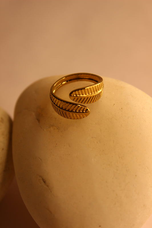 Adara Ring on a beige surface with a blurred background