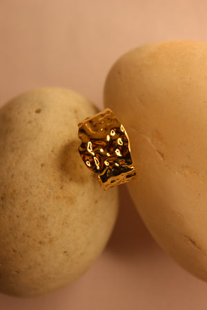 Molte Ring on a stone surface with a soft pink background