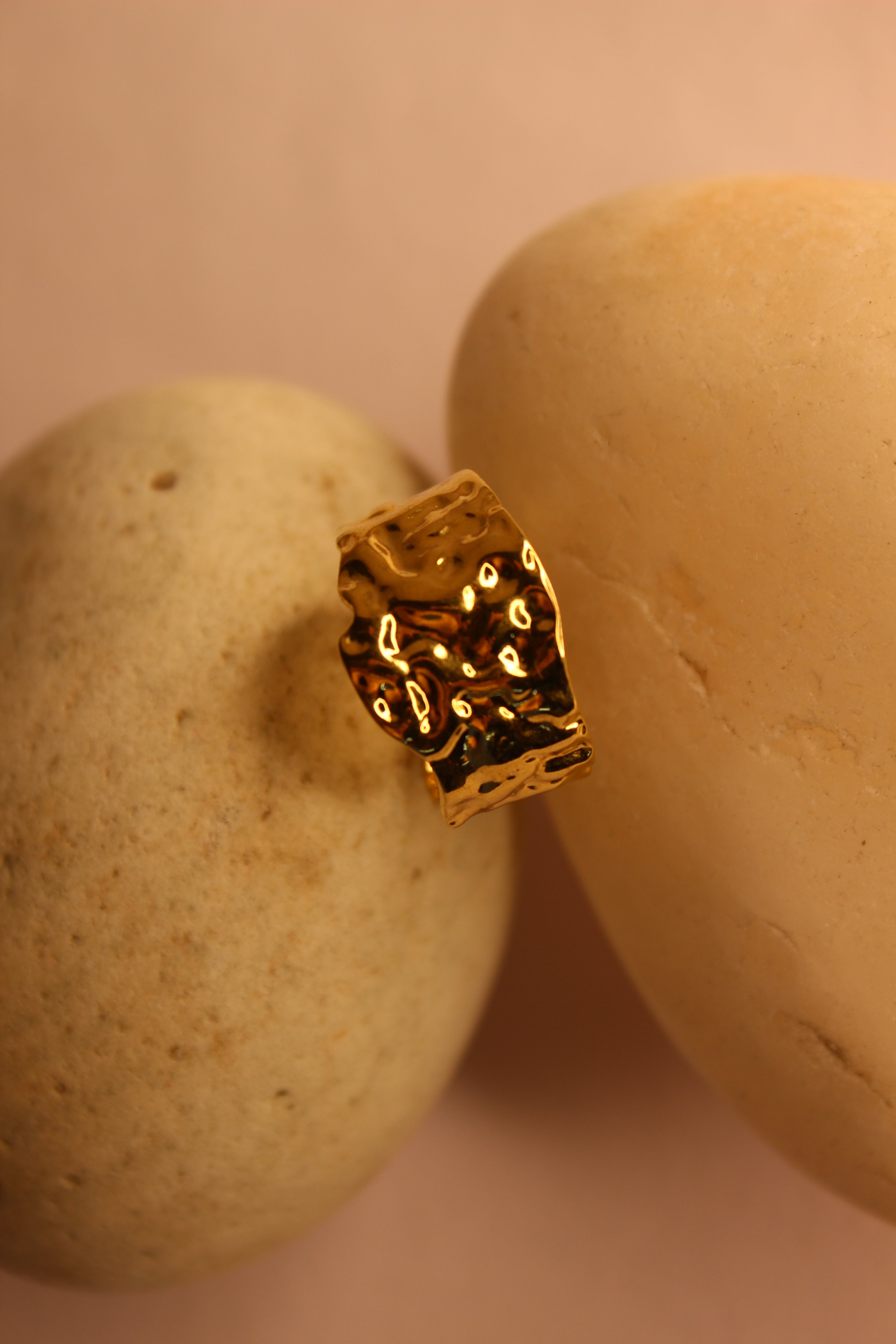 Molte Ring on a stone surface with a soft pink background