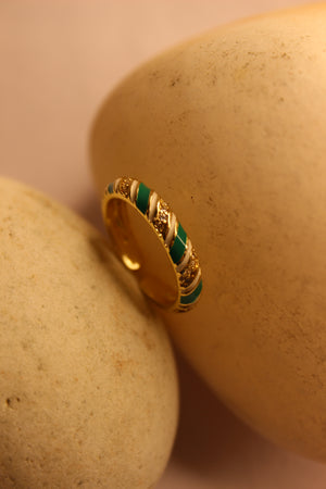 SolPop Ring with green accents on a beige stone surface