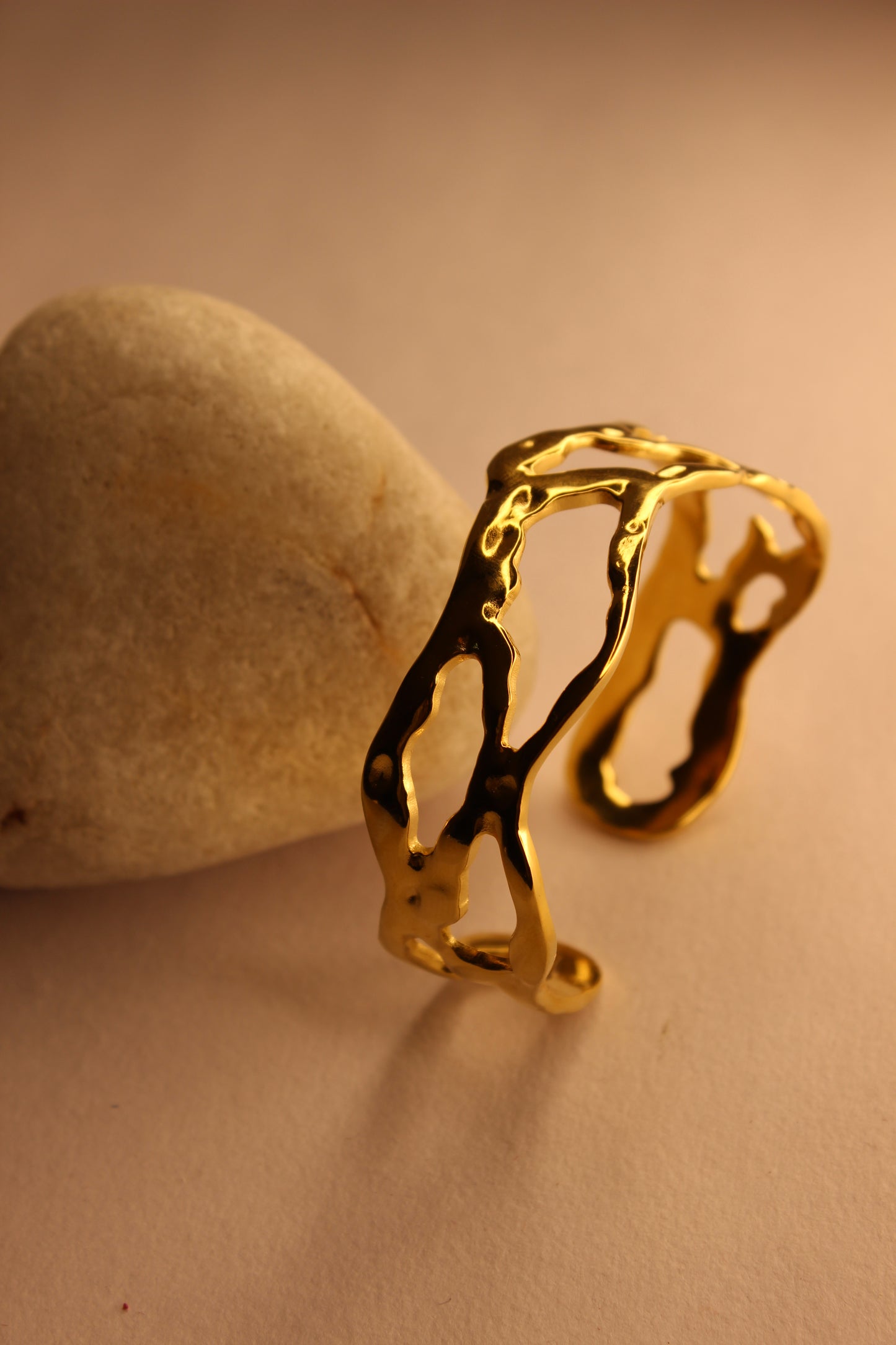 Orra Cuff Bracelet on a stone surface with a plain background