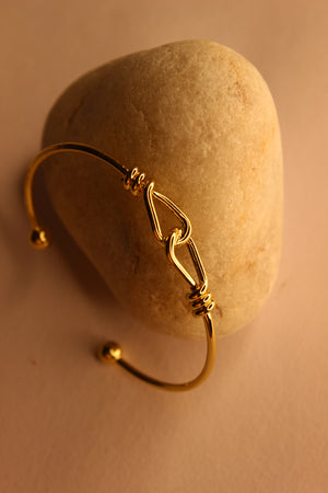 Tether Cuff Bracelet on a stone surface with a warm beige background