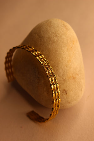 Meira Cuff Bracelet on a stone surface with a warm color tone