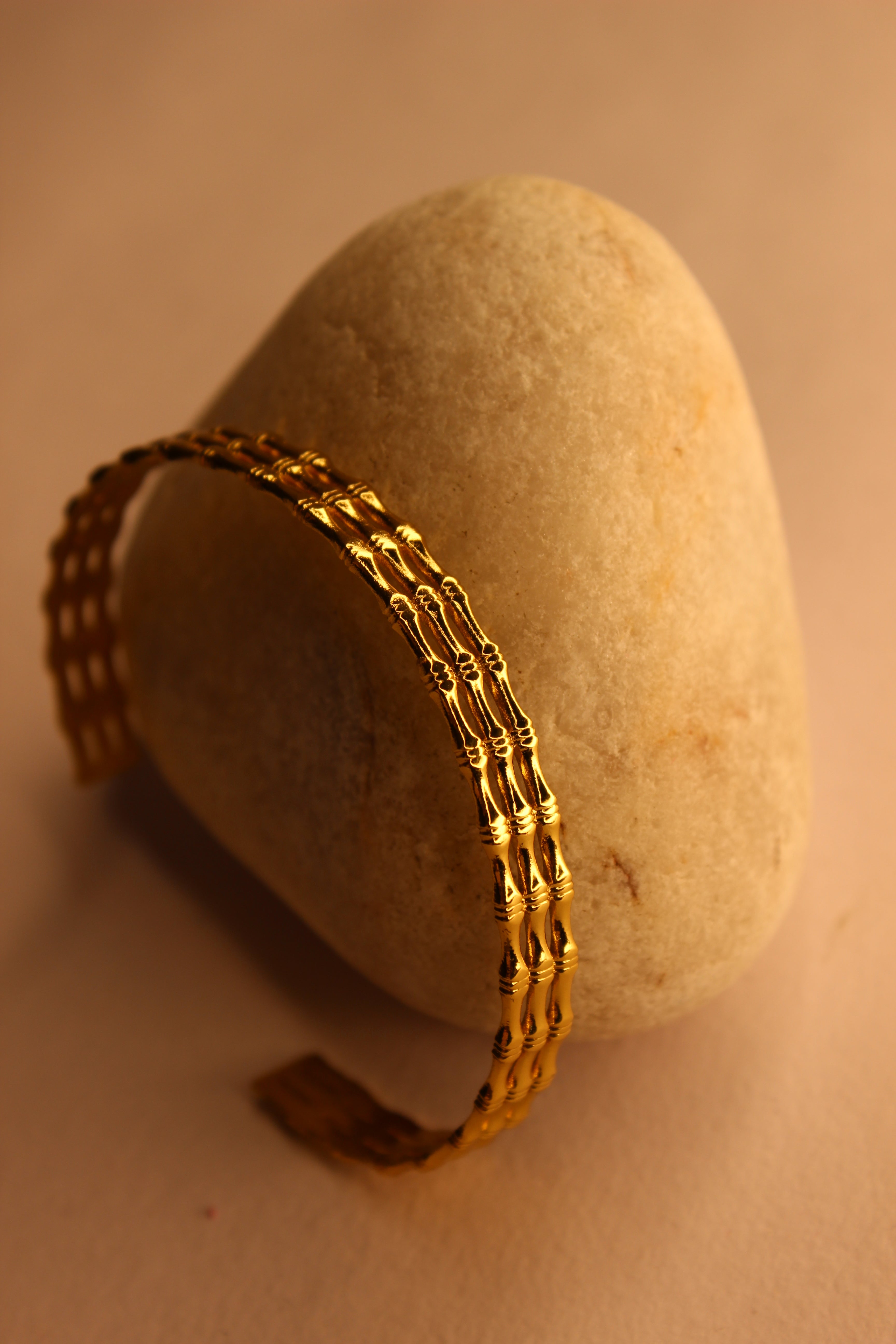 Meira Cuff Bracelet on a stone surface with a warm color tone