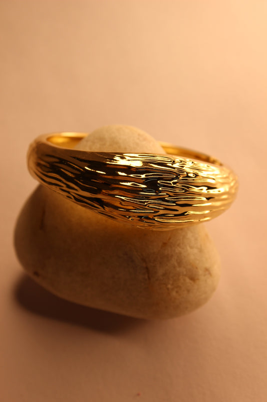 Elegant gold Yara bangle bracelet on light background 