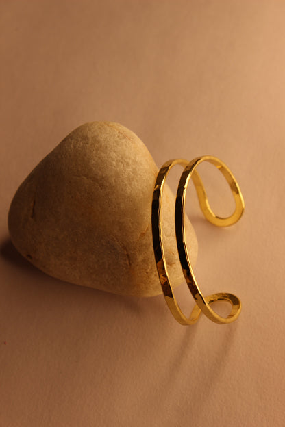 Elaris Cuff Bracelet on a stone with a beige background