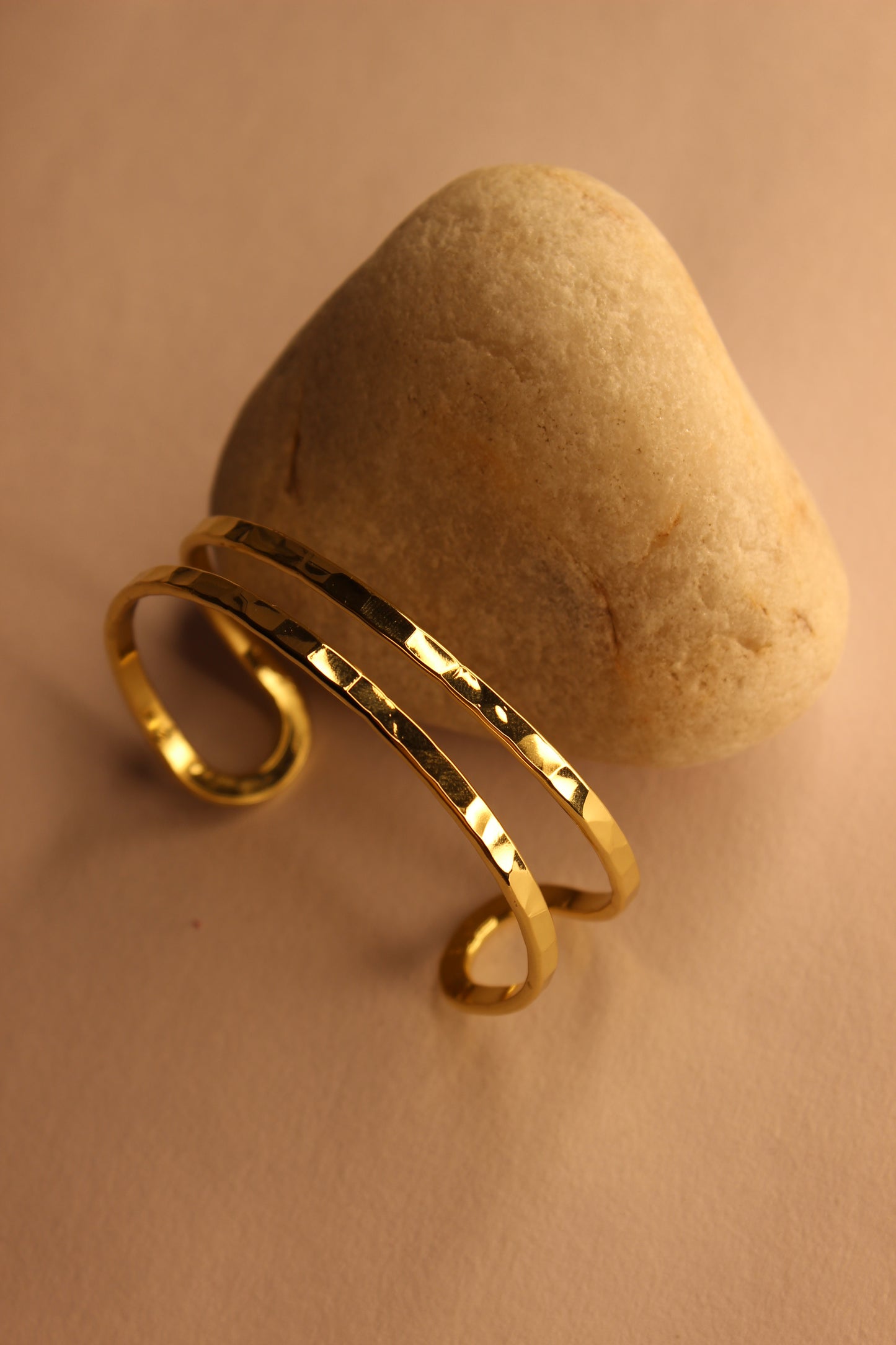 Elaris Cuff Bracelet on a beige stone surface