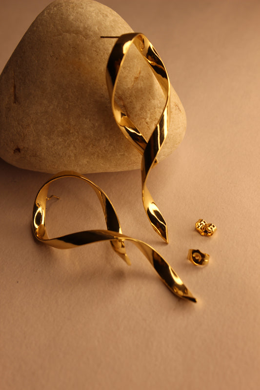 Selene Wave Earrings on a beige stone surface