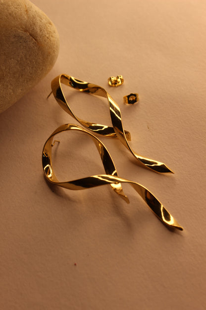 Selene Wave Earrings on a beige surface