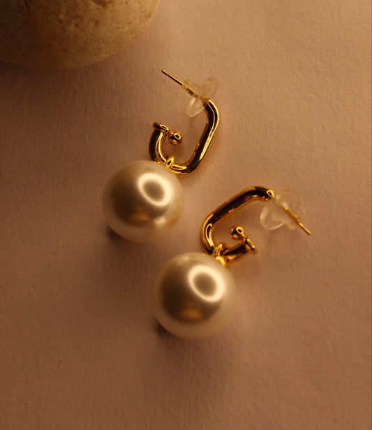 Luna Pearla Earrings on a beige background