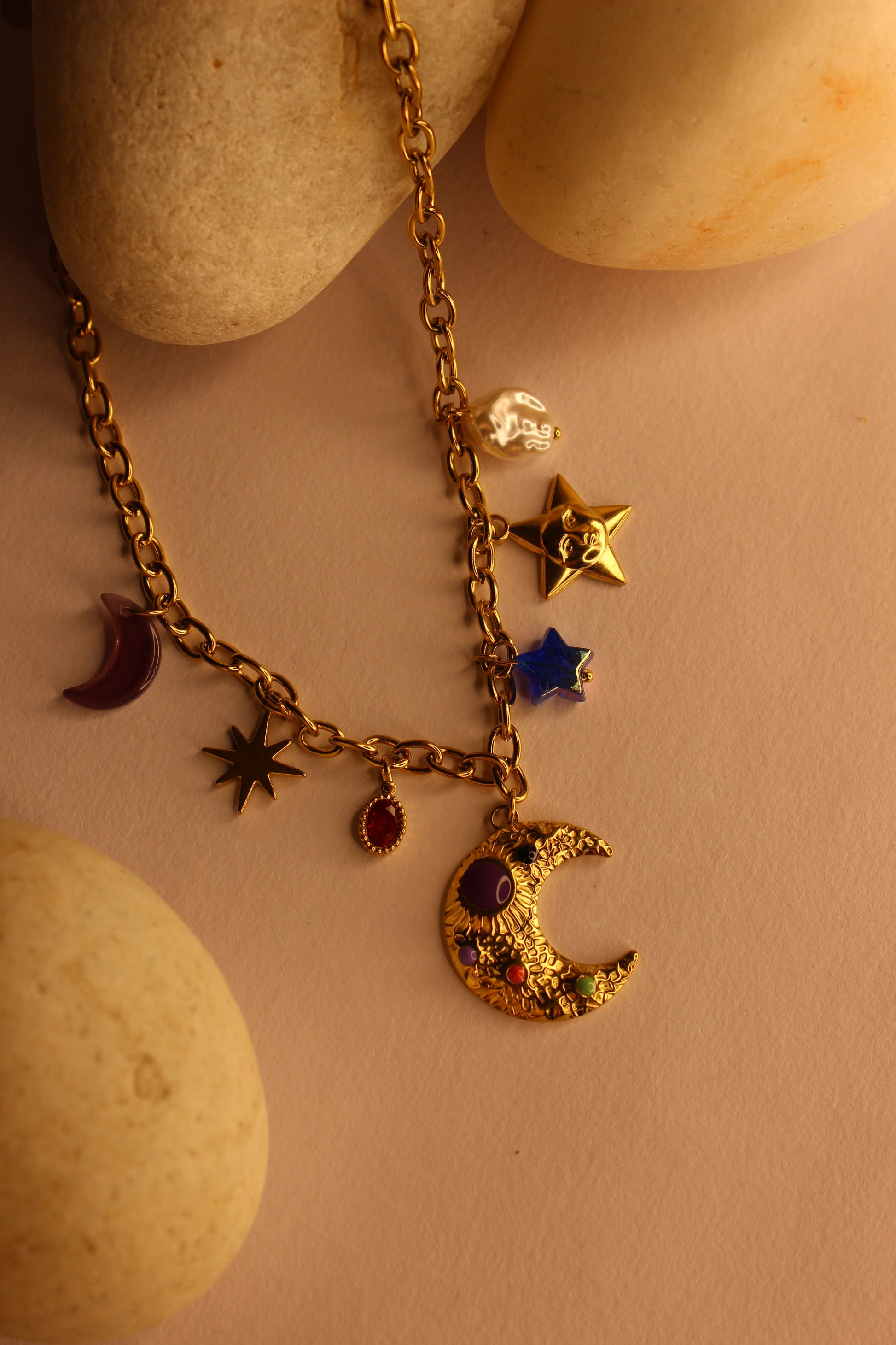Lunar Spells Charms Necklace on a beige stone background