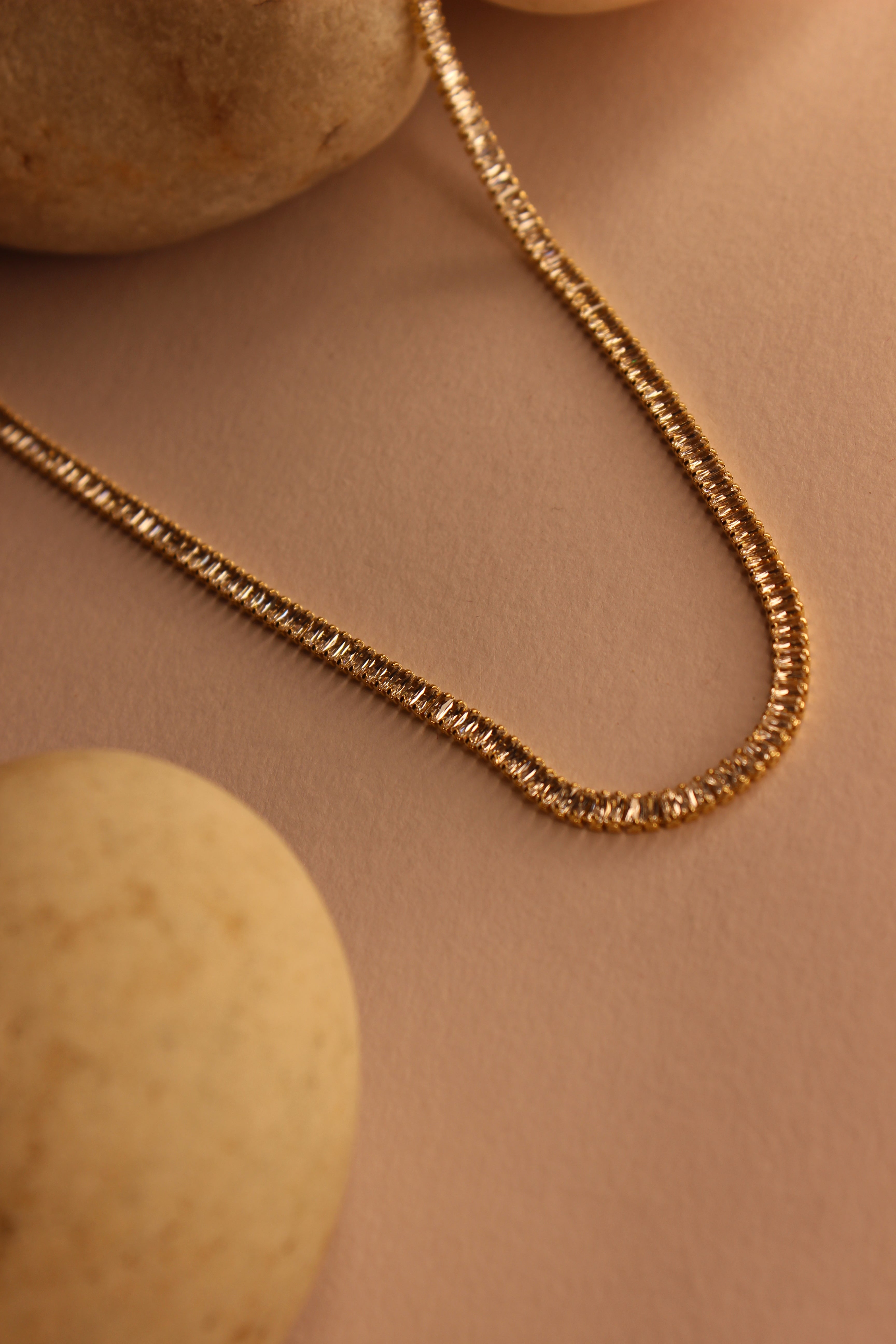 Twilite Necklace on a beige background with stones