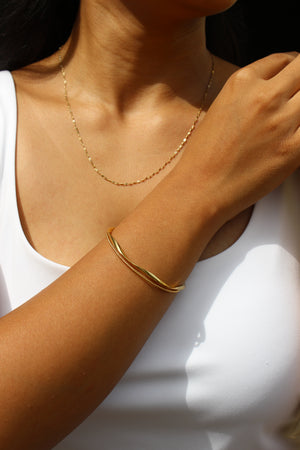 Close-up of a model wearing a Auriin Cuff Bracelet on a plain background