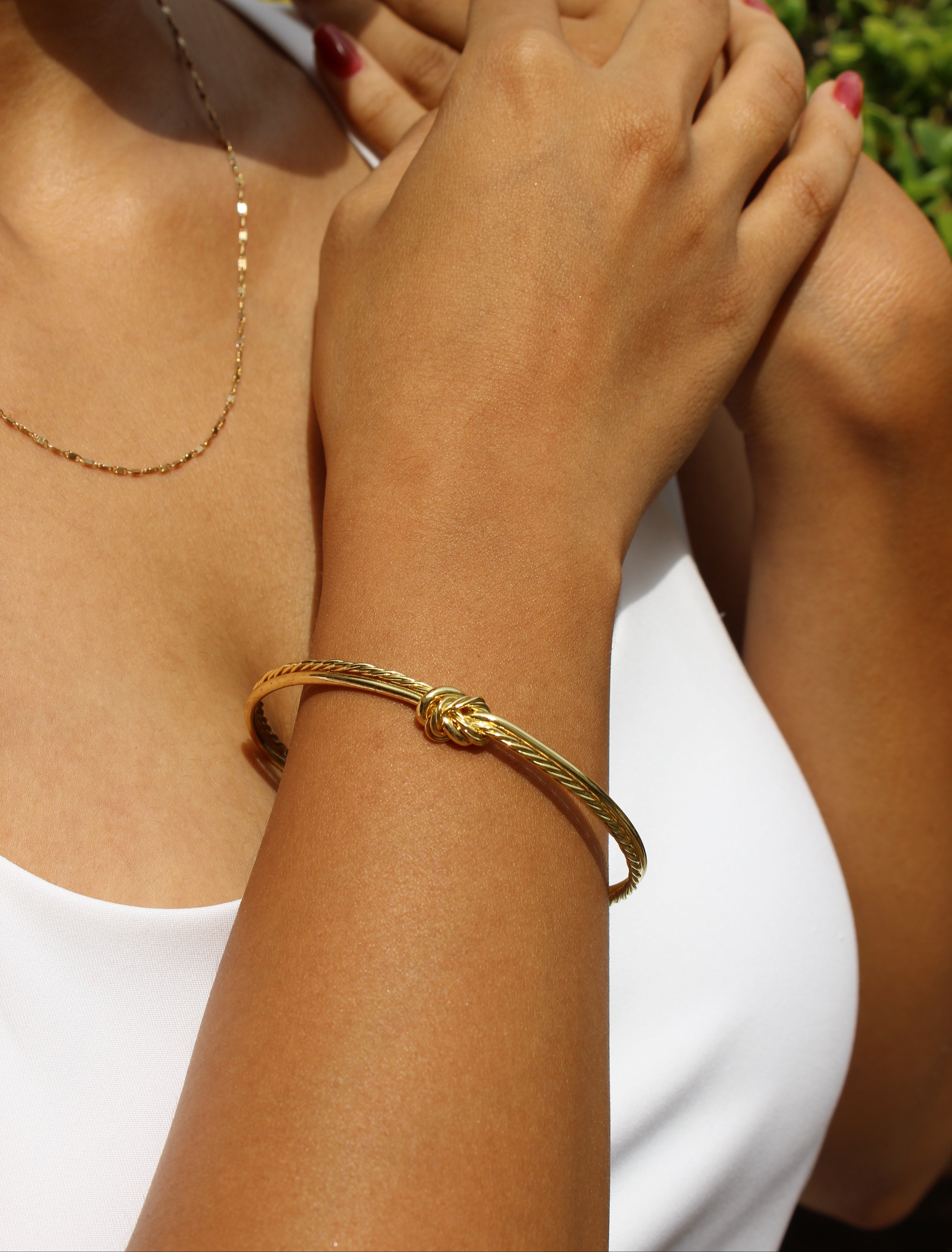 Close-up of a model's wrist wearing a Knota Cuff Bracelet with a blurred background