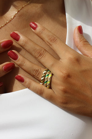 Hand with red nail polish wearing a SolPop Ring on a white background