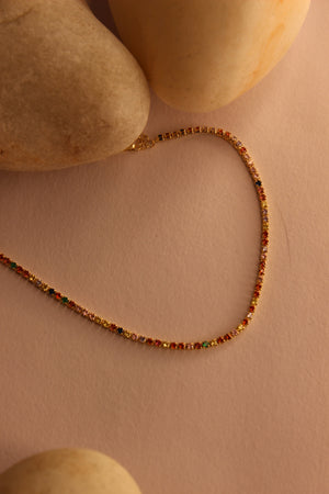 Colorbind Necklace on a beige surface with stones