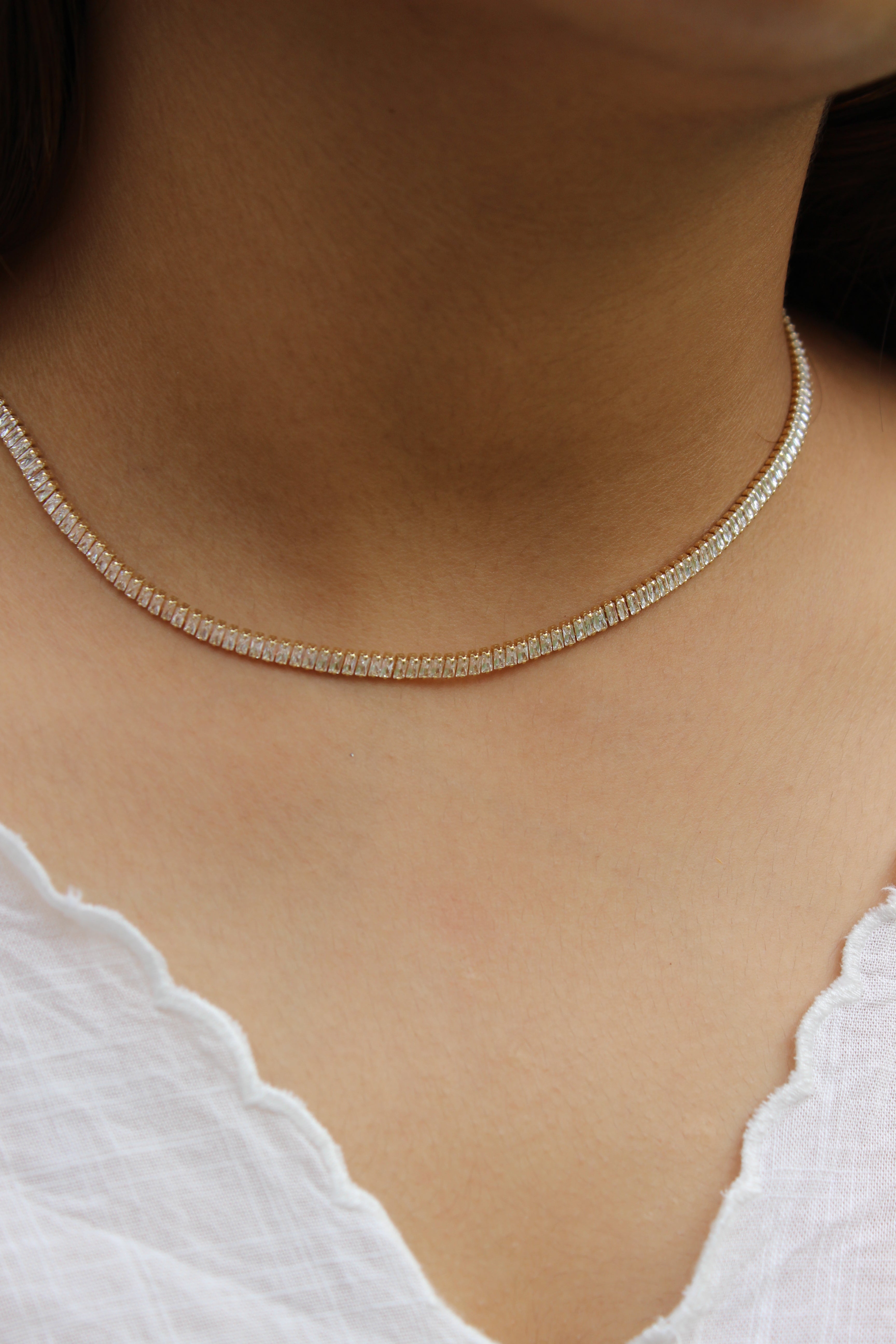 Close-up of a Twilite Necklace on a model's neck with a blurred background