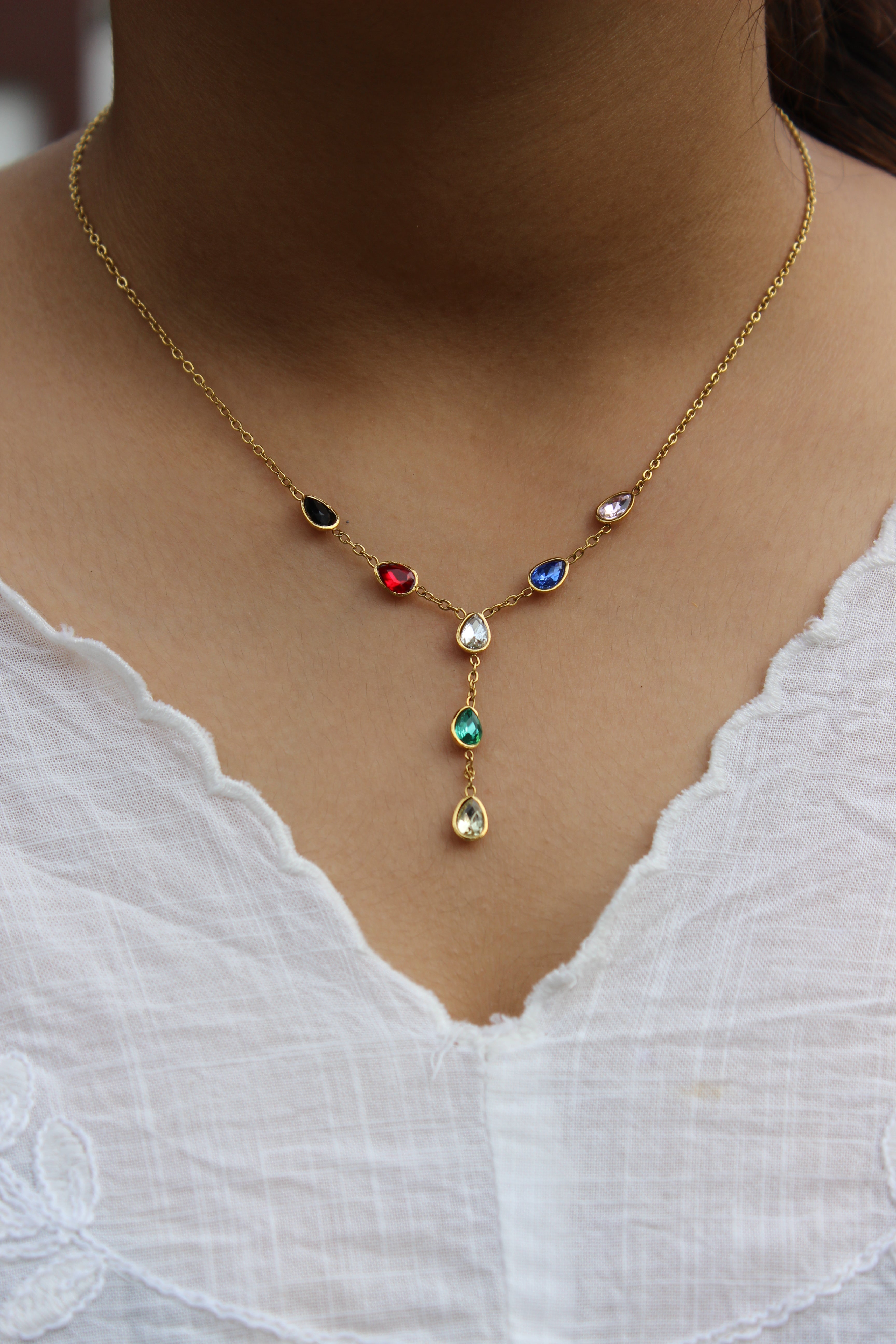 Prism Drop Necklace on a model's neck against a white fabric background